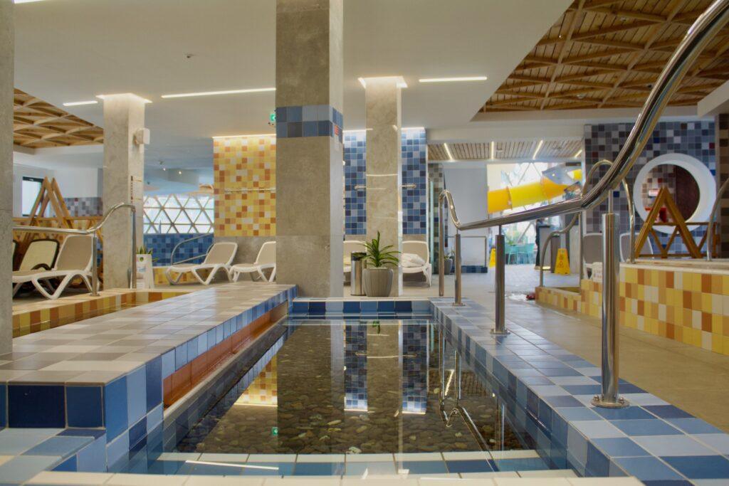 Piscină cu balustradă și mozaic în culori calde