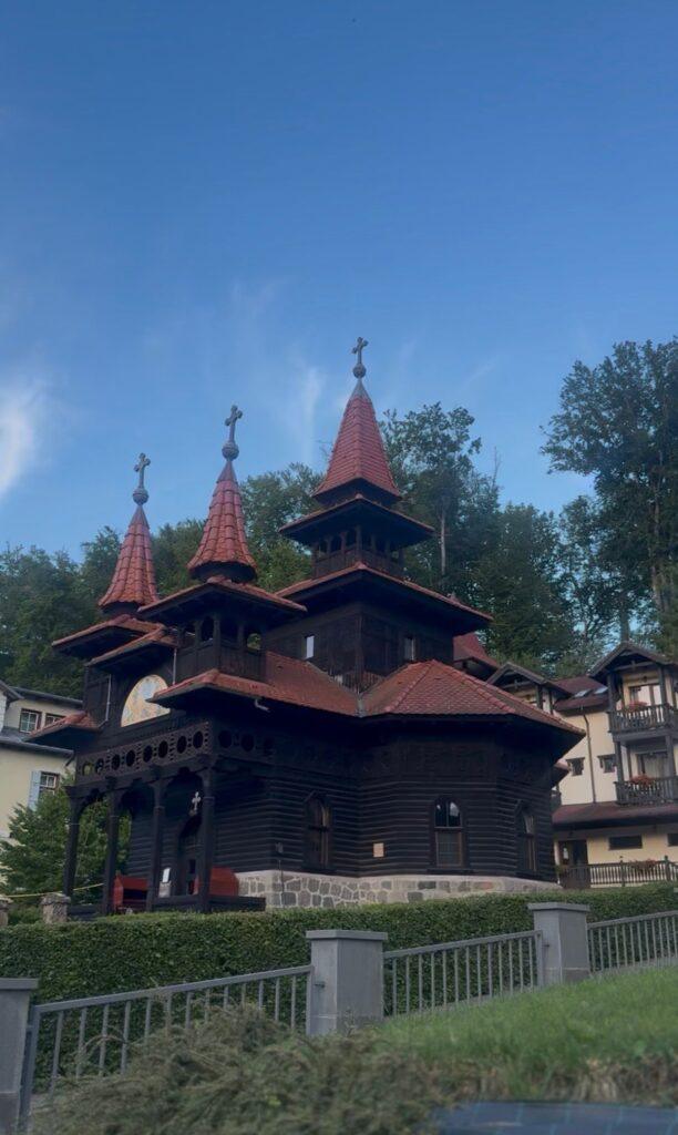 Clădire cu acoperișuri roșii și lemnărie decorativă în Sovata