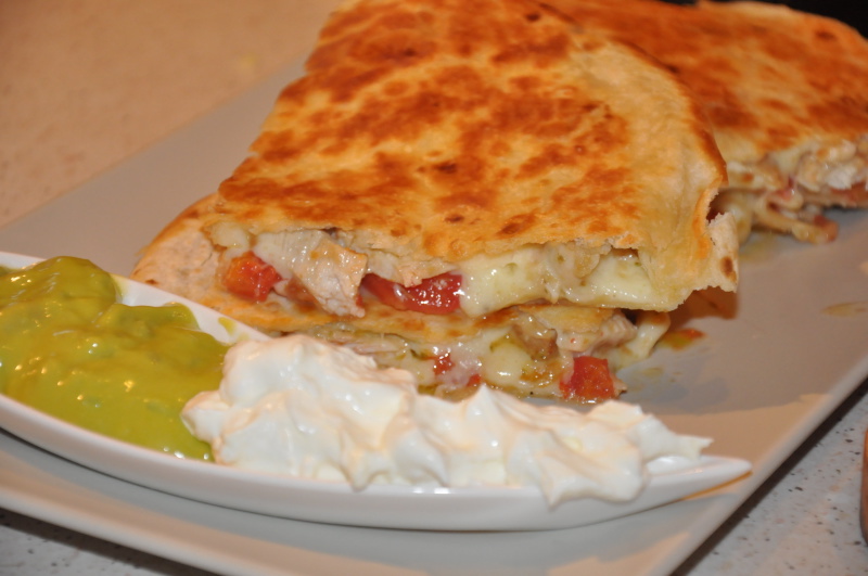 quesadilla Bucăți de quesadilla rumenită cu sosuri pe farfurie